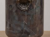 a large metal pot with a handle on a table