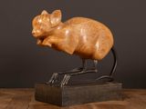 une photo d'une sculpture représentant un chat posée sur un socle en bois