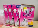 three packs of liquid snacks sit on a table next to a bag of liquid