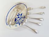 a lot of silverware on a plate on a white table