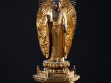 une statue en or représentant un Bouddha assis sur une table