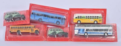 quatre petits bus de différentes couleurs dans un emballage rouge