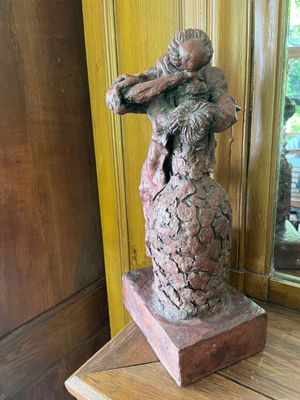 a statue of a woman holding a child on a table