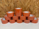 plusieurs rouleaux de ruban adhésif orange empilés les uns sur les autres