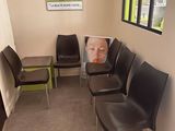 chairs in a waiting room with a picture of a baby on the wall
