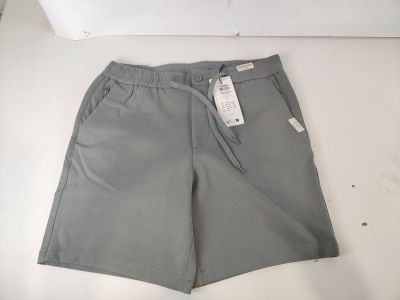 un short gris posé sur une table blanche, avec une étiquette dessus