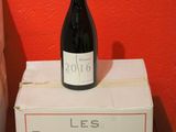 a bottle of wine sitting on top of a box next to a toilet
