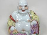 une figurine représentant un Bouddha souriant assis sur un coussin