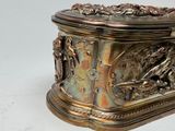 a silver box with a bird on it sitting on a table