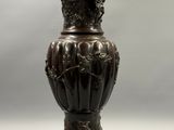 un vase en bronze posé sur une table