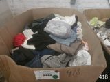 a cardboard box full of clothes that is sitting on the floor