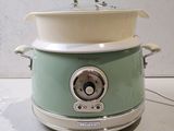 a green and white crock pot sitting on a counter