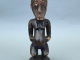 une image représentant une statue en bois d'un homme en costume