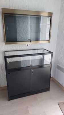 une armoire noire ornée d'un miroir, dans une pièce