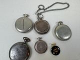 many different types of pocket watches on the table
