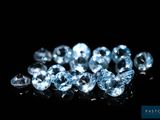 a close up of a bunch of blue diamonds on a black surface
