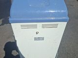 a blue and white refrigerator sitting on the side of the road