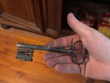 a person holding a key in their hand on the floor