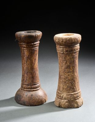 une paire de salières et poivrières en bois posées sur une surface grise