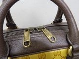 a brown and yellow handbag with a gold handle
