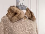 a sweater with a fur collar on a mannequin
