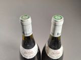 two bottles of wine sitting next to each other on a table
