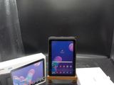 une tablette posée sur une table, à côté d'une boîte