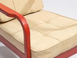 a red chair with a beige cushion on it
