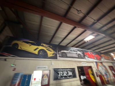 Il y a beaucoup de voitures accrochées au mur dans ce garage.