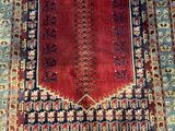 a red and blue rug with a floral design on it