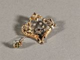 a gold brooch with a heart and flowers on it