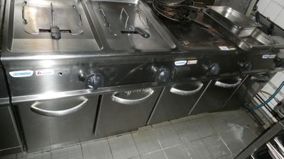 une cuisine équipée de nombreux appareils électroménagers en inox