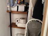 un petit placard avec une chaise et un portant à vêtements