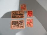 four stamps on a table with a shadow of a person holding a knife