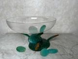 un bol en verre posé sur une table en marbre, avec quelques pierres en verre à l'intérieur