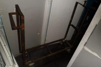 une petite salle de bains avec des toilettes et un chariot en métal
