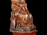 statue of a woman holding a child on a wooden base