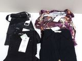 trois paires de pantalons noirs sont posées sur une table à côté d'un sac à main