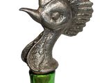 a green glass bottle with a silver bird on it
