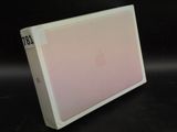 a white box with a pink cover sitting on a black surface