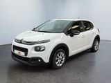 Une Citroën blanche est garée dans une pièce blanche
