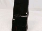 a black cell phone on a stand on a white surface