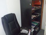 une chaise noire et une bibliothèque noire dans une pièce