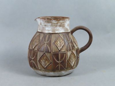 un vase marron et blanc muni d'une anse marron