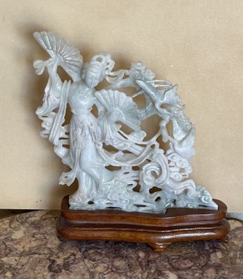 une statue représentant une femme tenant un éventail, posée sur une table