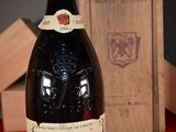 a bottle of wine sitting on a table next to a wooden box