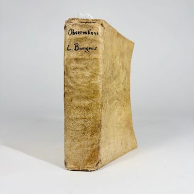 an old book sitting on top of a table next to a white wall