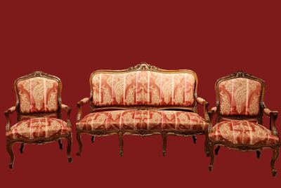 three chairs and a couch sitting next to each other on a red background