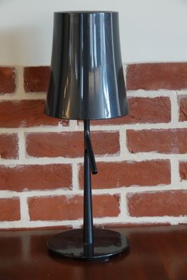 une lampe posée sur une table devant un mur de briques