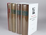 three books are stacked on top of each other on a white surface